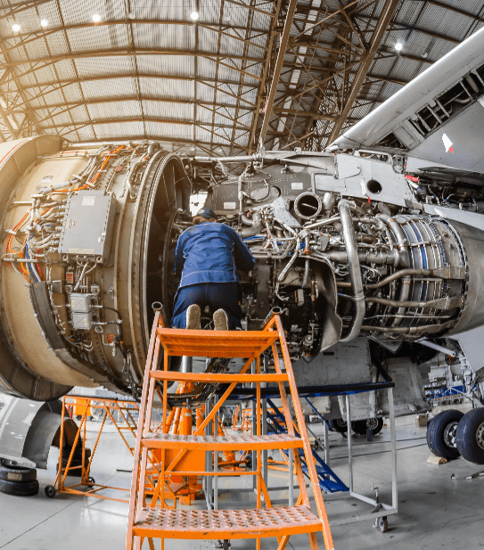 Specialist mechanic repairs the maintenance of a large engine of a passenger aircraft in a hangar-min